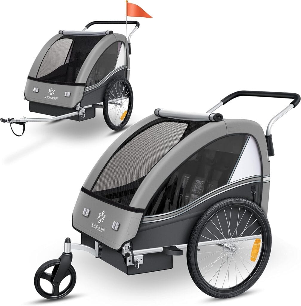 Przyczepka rowerowa KESSER® Sport-RX dla dzieci, szara, z siatką ochronną i pompowanymi kołami. Wyposażona w odblaski, flagę bezpieczeństwa oraz przednie koło obrotowe 360°. Idealna na wycieczki, spacery i codzienne dojazdy.