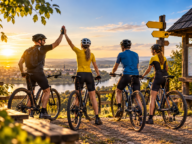 Grupa rowerzystów z rowerami planująca wspólną trasę podczas klubowego wyjazdu rowerowego.
