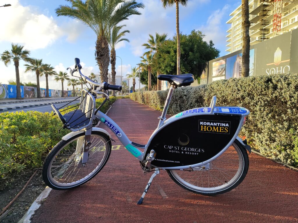 Rower Nextbike w Pafos na ścieżce rowerowej przy palmach i promenadzie nad Morzem Śródziemnym