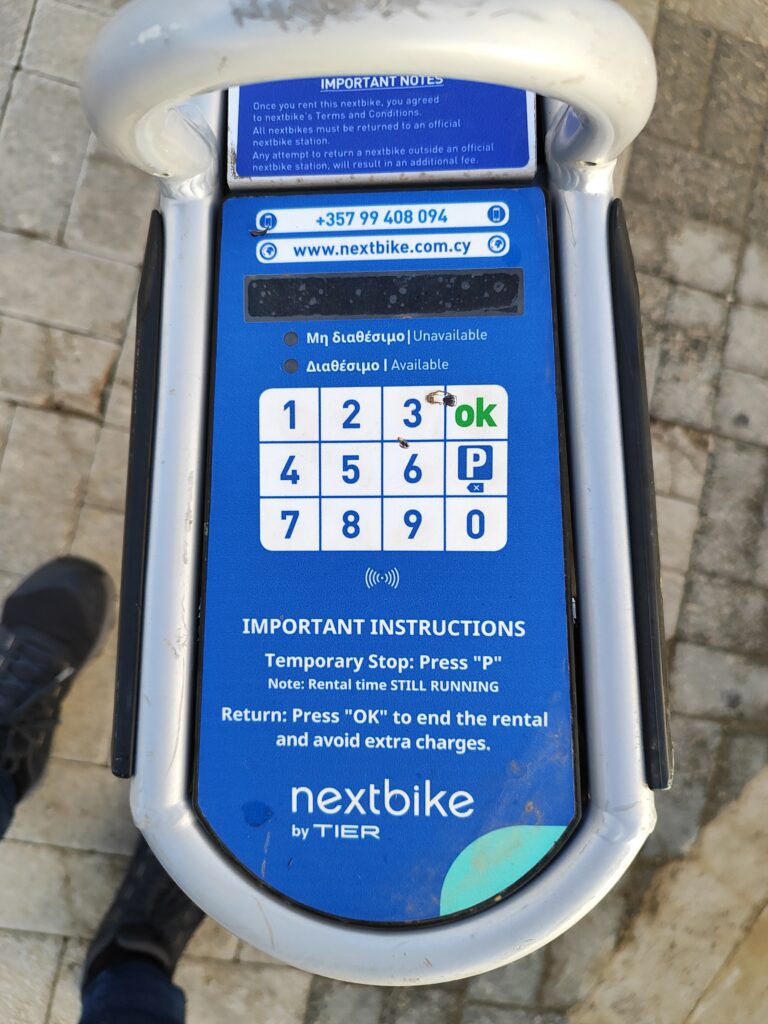 Nextbike Pafos – terminal i klawiatura na rowerze miejskim, przyciski P i OK oraz skrócona instrukcja zwrotu