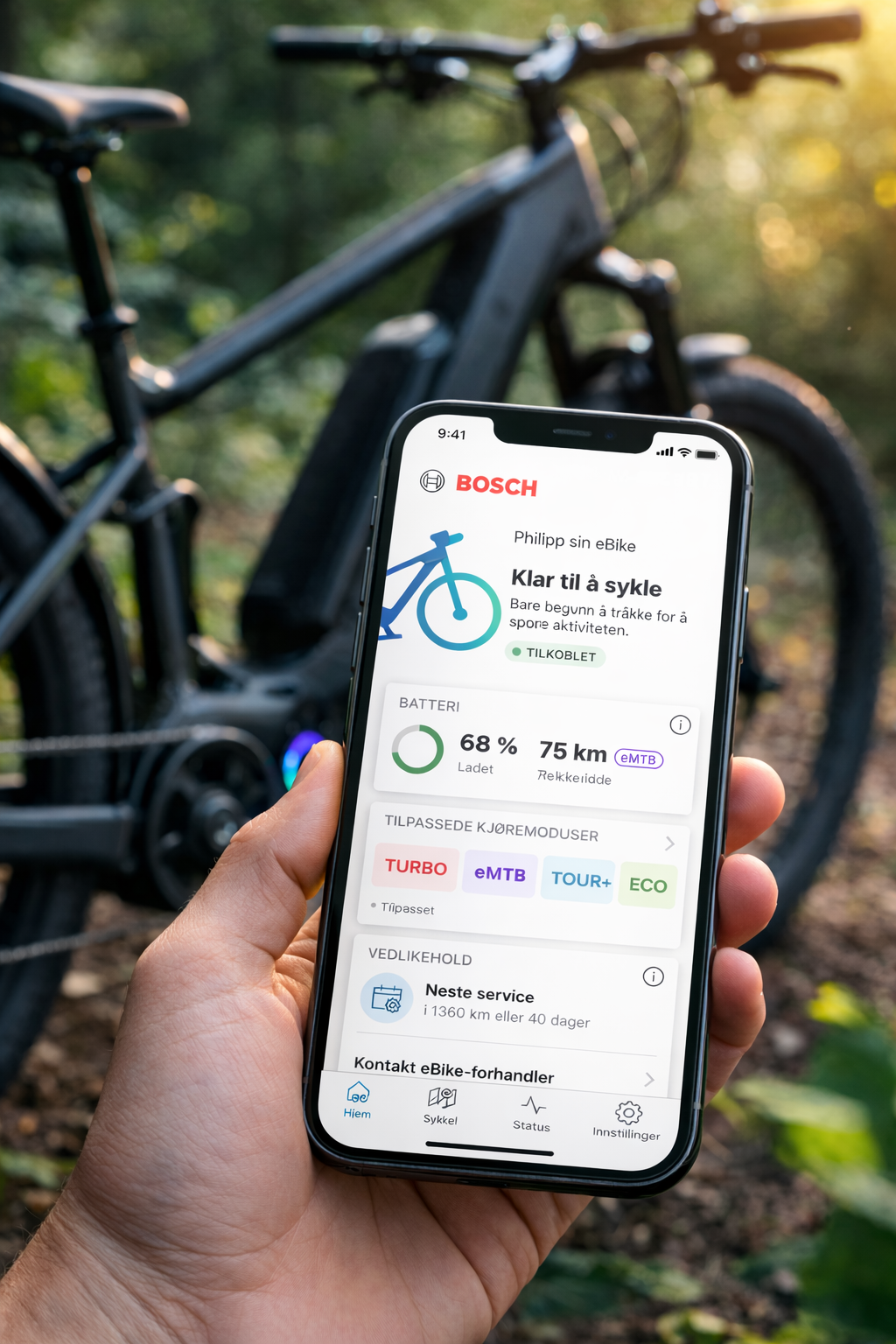 Aplikacja Bosch eBike Flow na ekranie smartfona – podgląd baterii, trybów jazdy i statusu roweru elektrycznego Bosch Smart System w terenie leśnym.