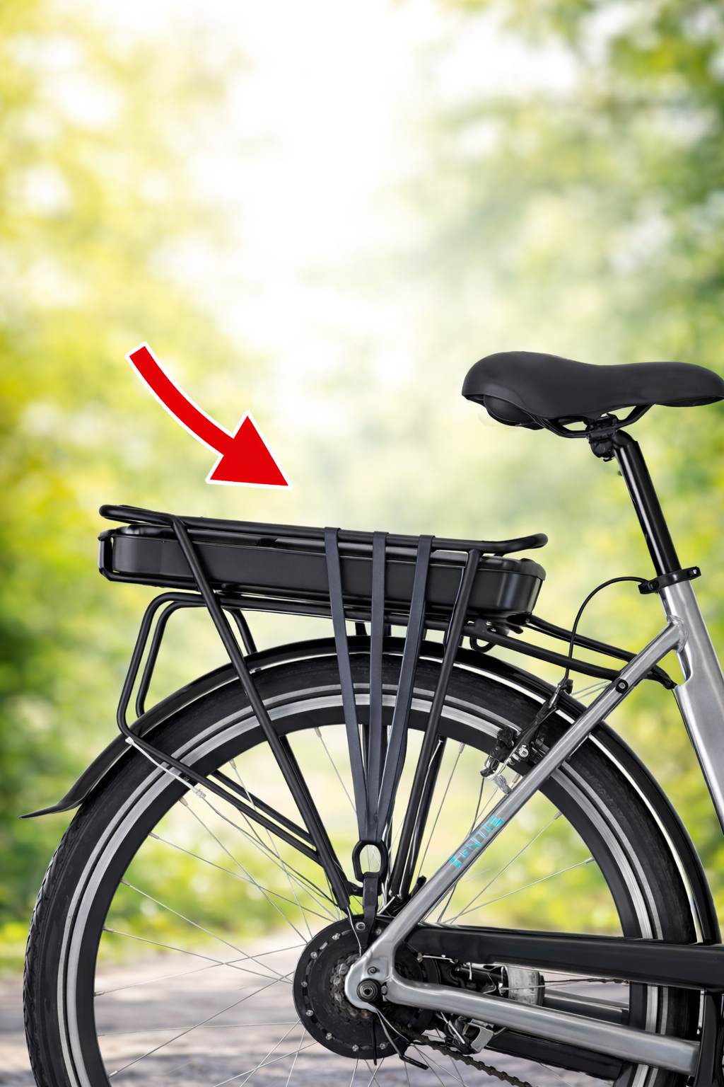 Rower elektryczny z baterią na bagażniku – widok tylnej części roweru miejskiego z akumulatorem zamontowanym na tylnym bagażniku i strzałką wskazującą baterię.