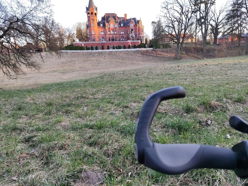 Ergon GP5 L zamontowane na rowerze elektrycznym – widok z boku, w tle pałac w Wąsowie