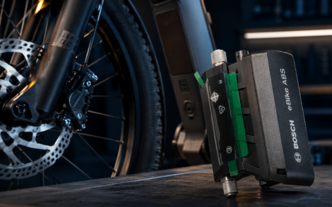 Moduł Bosch eBike ABS obok przedniego koła roweru elektrycznego z hamulcem tarczowym.