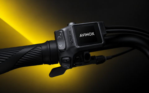 Sterownik AVINOX na kierownicy roweru elektrycznego na czarno-żółtym tle